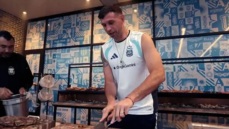 Dibu Martínez fazendo o famoso "asado argentino" na concentração da Copa de 2026.