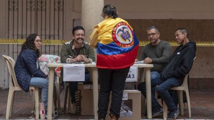 Uma mulher vestindo a bandeira da Colômbia registra-se para votar durante a eleição presidencial em Bogotá. na Colômbia.