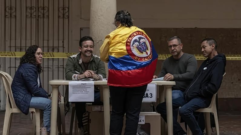 Uma mulher vestindo a bandeira da Colômbia registra-se para votar durante a eleição presidencial em Bogotá. na Colômbia.