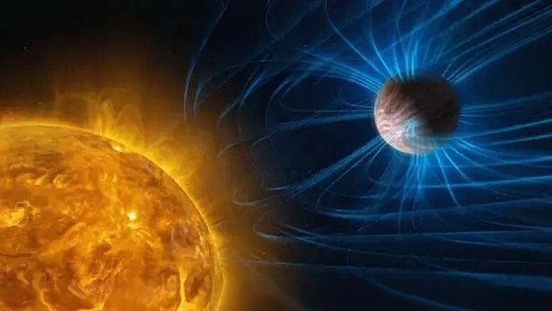 Representação artística de um sol laranja flamejante à esquerda e um planeta marrom-claro à direita, envolto por linhas azuis brilhantes que simulam um campo magnético