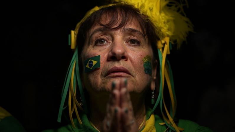 Torcedora assiste apreensiva à partida entre Brasil e Costa Rica em um telão no bairro de Alzirão, no Rio de Janeiro