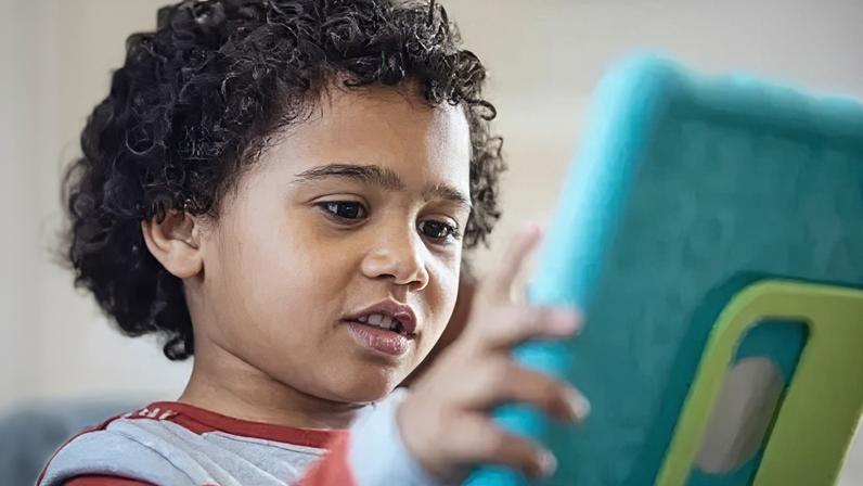 A young child looking at a tablet in a protective case