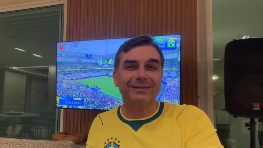 Flávio Bolsonaro disse que “o que está em jogo no Brasil está muito acima de qualquer vaidade”; a equipe brasileira enfrenta a seleção da Escócia pela última rodada da fase de grupos da competição