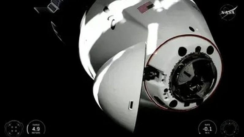 Nesta captura de tela do canal do YouTube da NASA, a cápsula Dragon da SpaceX, que transporta a tripulação da Crew-12, acopla-se à Estação Espacial Internacional no sábado, 14 de fevereiro de 2026