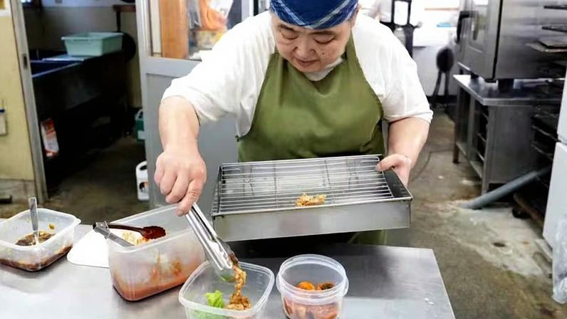 Funcionário de restaurante no Japão coloca alimentos nos recipientes levados pelo cliente