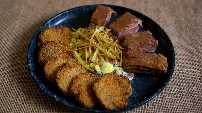 Prato do bar vencedor do Comida di Buteco leva risoto de canjica com couve, bacon, linguiça e costelinha com mostarda de jabuticaba, servido com crispy de alho-poró e chips de jiló