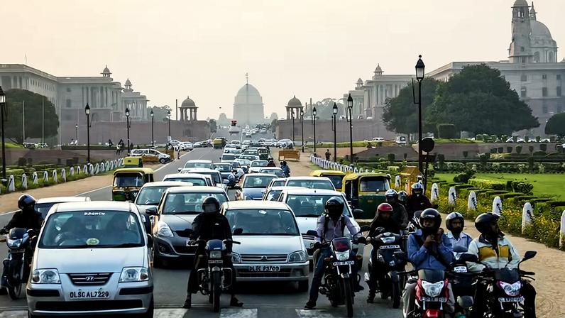 Carros e motos parados em sinal de trânsito em Nova Delhi, na Índia