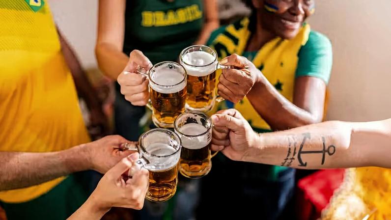 Grupo de amigos brinda com camisas da seleção de futebol — Foto: Getty Images