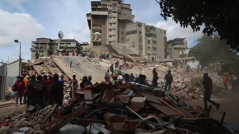 Pessoas e equipes de resgate trabalham nos escombros do edifício Moises, na Avenida Anauco, após um terremoto de magnitude 7,2 atingir a Venezuela e outras regiões do Caribe em 25 de junho de 2026, em Caracas, Venezuela.