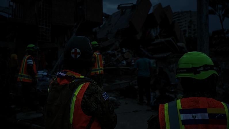 Equipes de resgate de El Salvador buscam vítimas entre os escombros de um prédio demolido em Catia La Mar, após um terremoto de magnitude 7,2 atingir a Venezuela