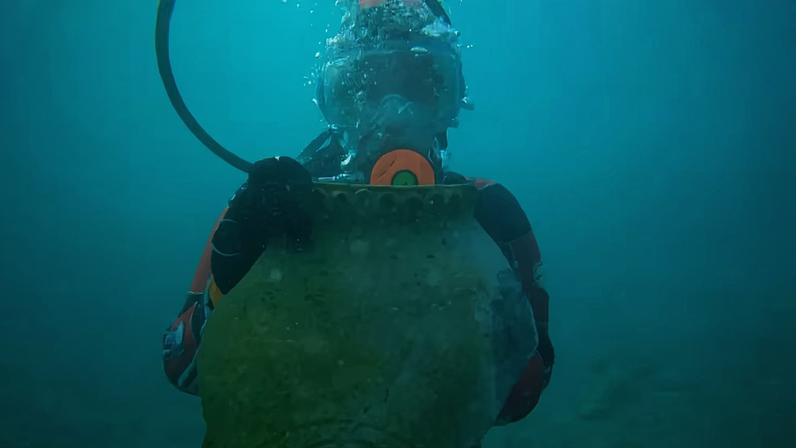 Kristina Guseynova, a laboratory assistant at the Institute of Archaeology of the Russian Academy of Sciences, with a part of an ancient jug