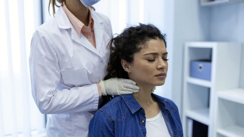 Endocrinologista examinando a garganta de uma jovem na clínica. Mulheres com exame da glândula tireoide. Endocrinologia, hormônios e tratamento. Inflamação da garganta. hipoparatireoidismo