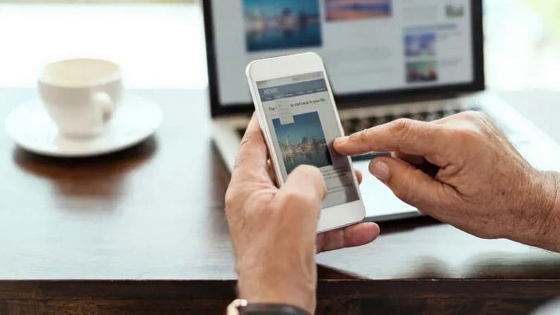 África está revolucionando o futuro do jornalismo com micropagamentos; na imagem, um homem lê notícias no telefone celular