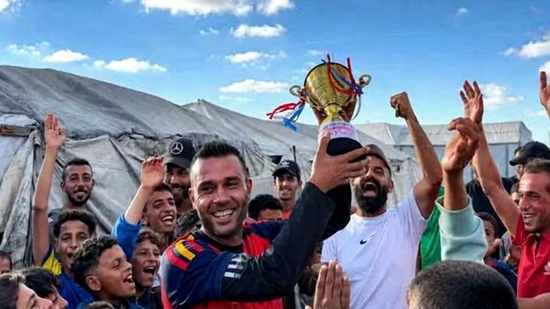 O palestino Asaad Al-Azzabi comemorando com a multidão de jovens e crianças a vitória do campo Al-Rahma de deslocados em campeonato de futebol — Foto: ONU News