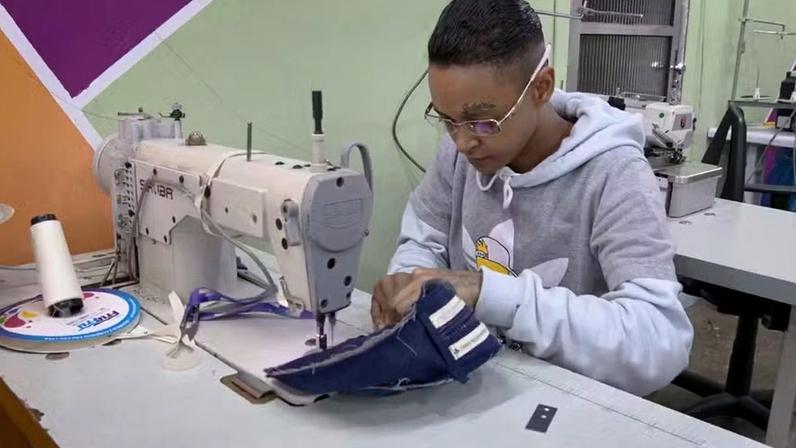 Participante do programa 'Feito em Casa', que transforma uniformes descartados em trabalho, renda e capacitação profissional para mulheres no sistema prisional.
