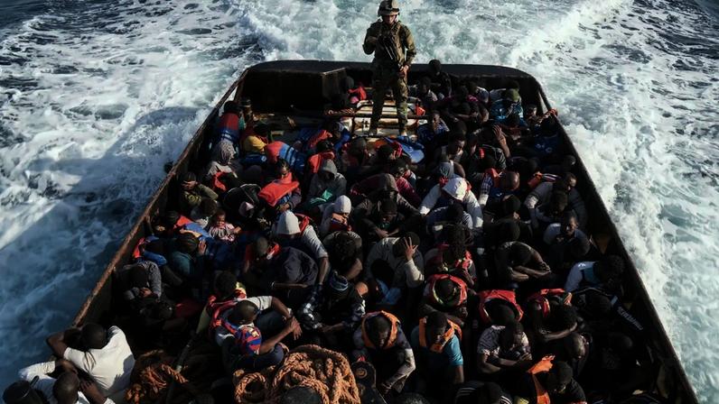 Soldado da guarda costeira da Líbia acompanha um barco com 147 imigrantes ilegais que tentavam chegar à Europa a partir da cidade costeira de Zawiyah, a oeste de Trípoli - 27/06/2017 (Taha Jawashi/AFP)