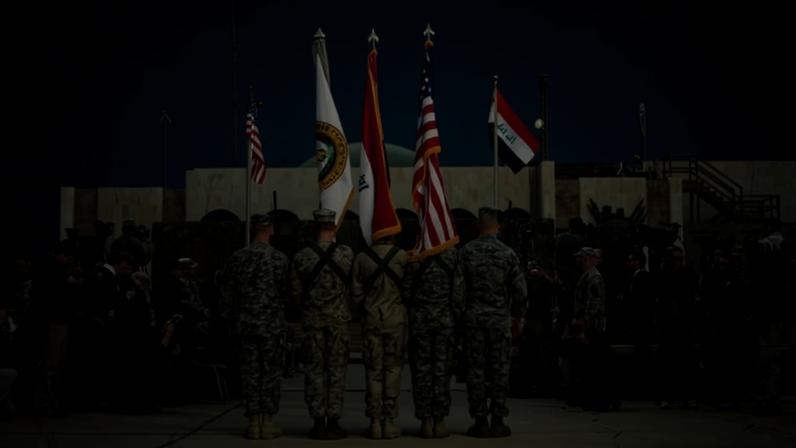 Soldados carregam as bandeiras dos EUA, Iraque e das forças americanas durante a cerimônia que marcou o fim da missão militar americana no país