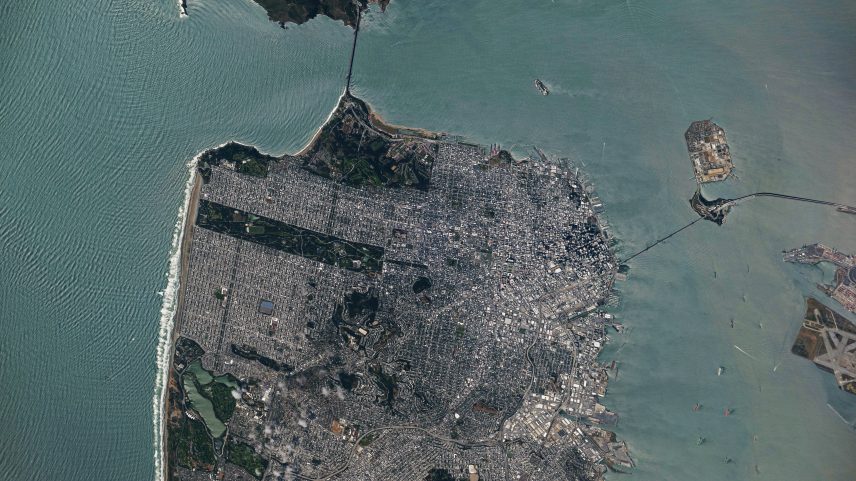 A view of downtown San Francisco from the International Space Station. The city's streets are visible in the daylight, as well as the Golden Gate Bridge to the north and the San Francisco-Oakland Bay Bridge connecting to Oakland to the east.