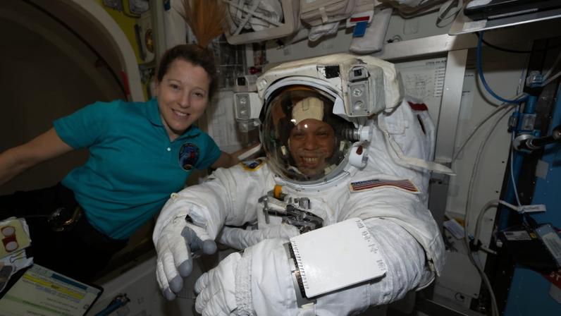 Flight engineer Sophie Adenot of ESA (European Space Agency) assists flight engineer Chris Williams of NASA as he tries on his spacesuit, testing its comfort and mobility as well as its communications and life support systems inside the International Space Station’s Quest airlock. Williams was preparing for a spacewalk to replace a malfunctioning wrist joint on the Canadarm2 robotic arm, planned for June 30, 2026.