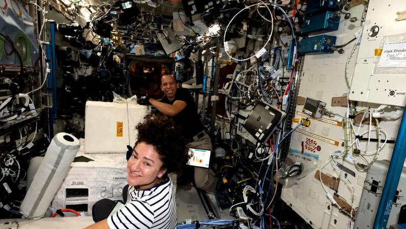 NASA astronauts Jessica Meir and Chris Williams collect frozen research samples while living and working aboard the International Space Station.