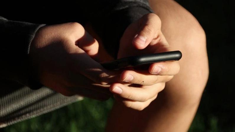 Países como Austrália e Malásia têm ampliado a fiscalização das redes sociais; na imagem, jovem utiliza celular