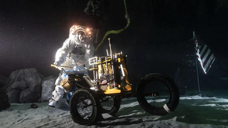 Wearing a spacesuit, Scott Wray conducts an underwater test in lunar night-like lighting at the bottom of the Neutral Buoyancy Laboratory pool.