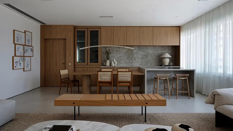 Na cozinha, a mesa de jantar, em folha de carvalho natural executada pela Jocarvi Marcenaria, é acoplada à ilha e recebeu cadeiras do acervo dos moradores. Luminária pendente Palo, de Wentz Design