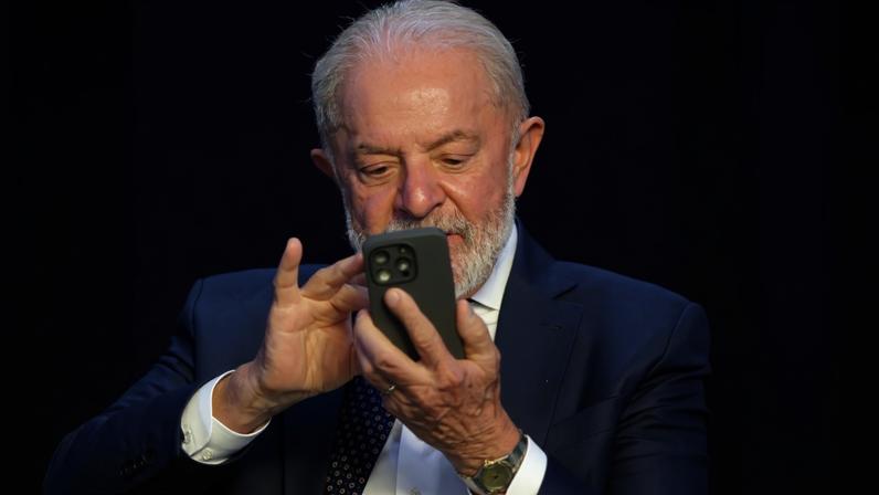Lula observa o celular