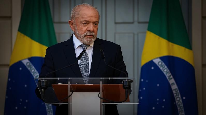 Presidente Lula com duas bandeiras do Brasil atrás