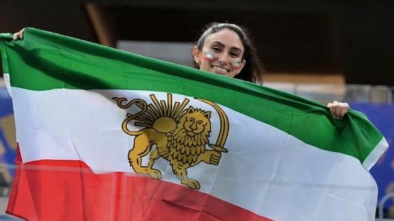 Manifestante com bandeira do Irã pré-revolução em jogo da Copa