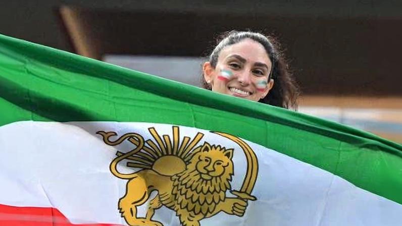 Manifestante com bandeira do Irã pré-revolução islâmica antes de jogo na Copa do Mundo