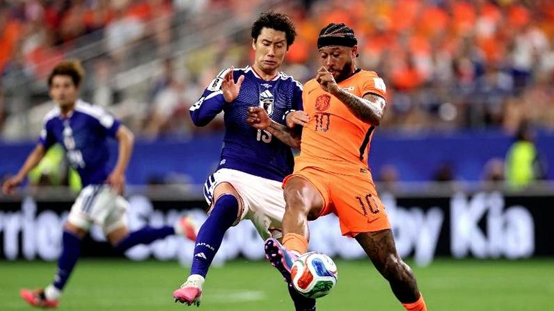 Memphis Depay disputa a bola com Daichi Kamada em Holanda x Japão, pela Copa do Mundo