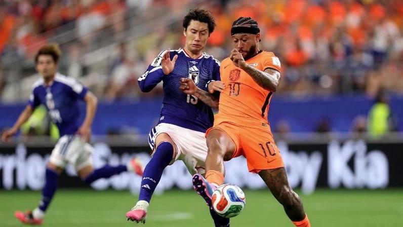 Memphis Depay disputa a bola com Daichi Kamada em Holanda x Japão, pela Copa do Mundo