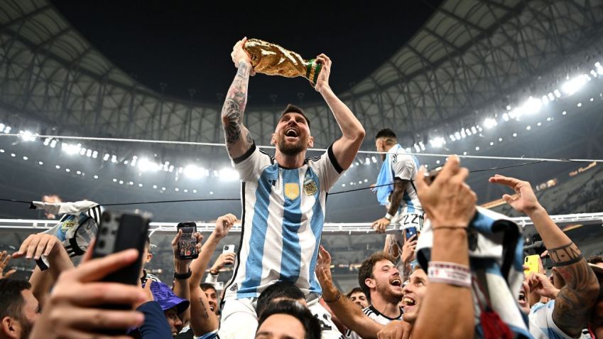 Lionel Messi ergue a taça da Copa do Mundo conquistada em 2022 no Catar • Shaun Botterill/FIFA/Getty Images