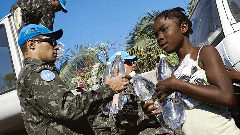 Militares brasileiros entregam água a moradores de Porto Príncipe após o terremoto que matou mais de 250 mil pessoas, em 2010