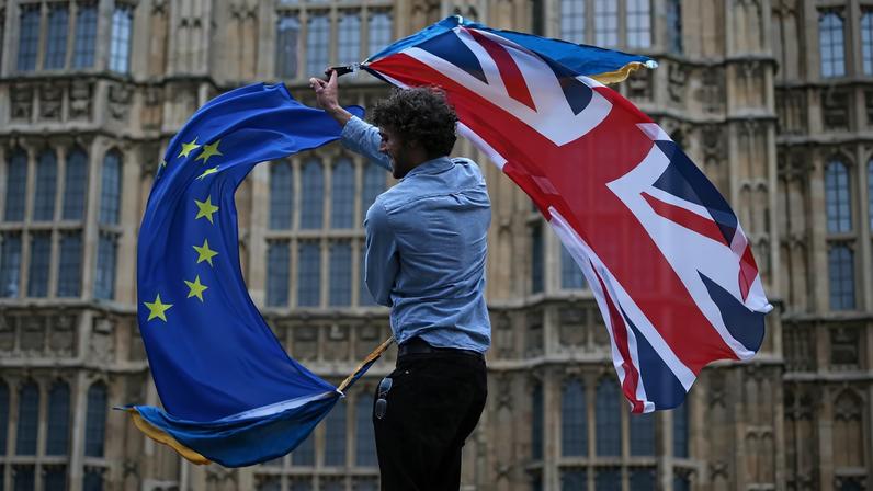 Homem agita uma bandeira do Reino Unido e uma da União Europeia em College Green, em frente ao Parlamento, durante um protesto contra o Brexit no centro de Londres, em 28 de junho de 2016