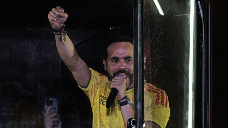 Colombia's presidential candidate for the Defensores de la Patria movement, Abelardo de la Espriella, speaks to supporters from behind bullet-proof glass following the preliminary results of the presidential runoff election at the Ventana al Mundo monument in Barranquilla, Colombia, on June 21, 2026. A flamboyant US-backed lawyer who has never held public office narrowly won Colombia's presidential runoff on June 21, swinging the country hard to the right on a promise to wage war against drug-running guerrilla groups. With just a handful of polling centers left to report, Abelardo de la Espriella had 49.65 percent of the vote -- an unassailable lead over left-wing Senator Ivan Cepeda who trailed on 48.70 percent. (Photo by Juan BARRETO / AFP)