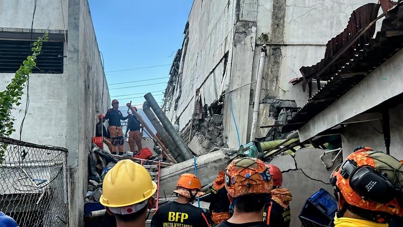 Equipes de resgate realizam uma operação de salvamento em um prédio que desabou após terremoto no sul das Filipinas