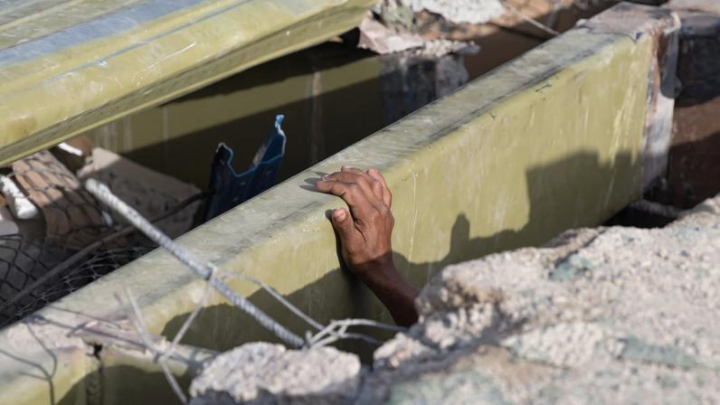 A mão de um voluntário enquanto ele busca sobreviventes entre os escombros de um prédio que desabou após dois terremotos em Caraballeda, no estado de La Guaira
