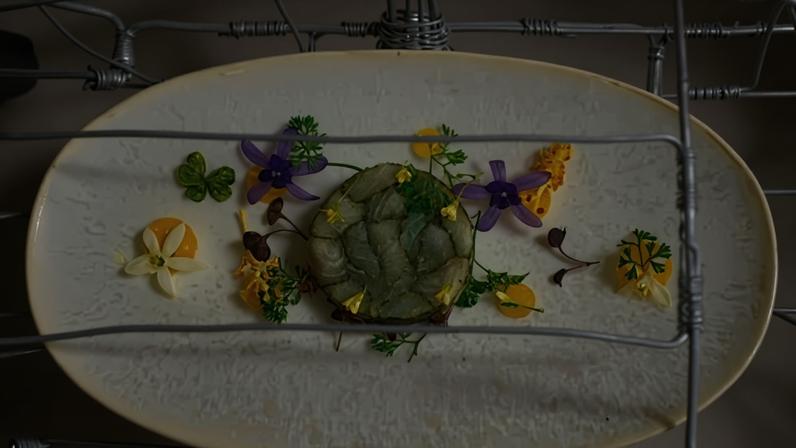 An elegant fish mould on a white plate surrounded by yellow and purple edible flowers (Credit: Courtesy of Sungani Restaurant)
