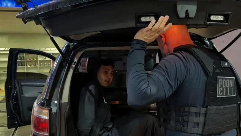 Foto colorida do momento em que Polícia Civil formaliza prisão de jovem suspeito de matar vizinho.