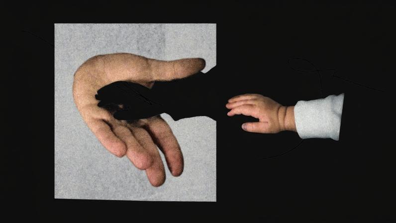 Paper cutouts of a father's hand and a small child's hand.