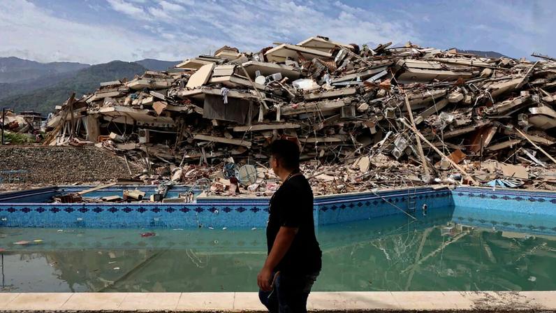 Homem caminha entre os escombros de prédios demolidos após um terremoto de magnitude 7,2 atingir a Venezuela - Metrópoles