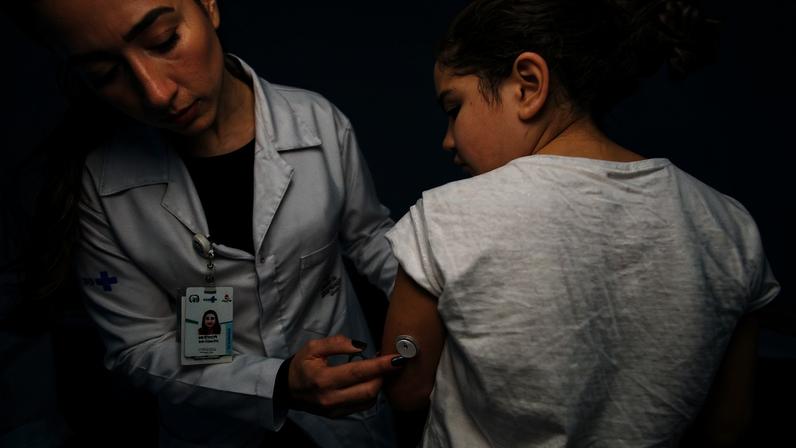 Fotografia colorida mostrando médica colocando sensor de glicose em criança-Metrópoles