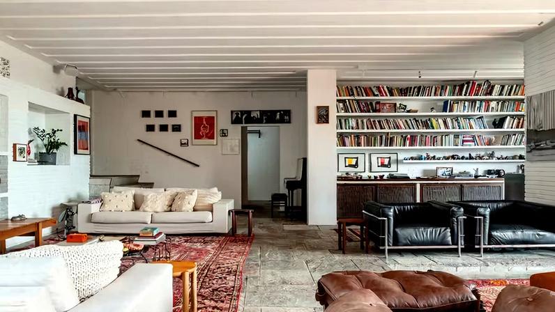 Na sala de estar, o sofá Stripes, da Prototype, convive harmoniosamente com as icônicas poltronas LC3, de Le Corbusier