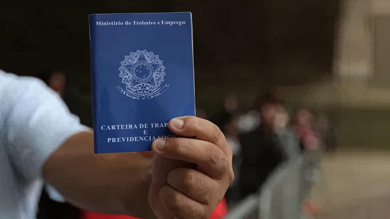 Homem mostra carteira de trabalho no centro de São Paulo