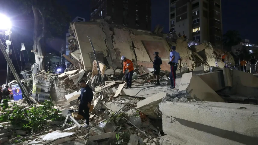 Integrantes de equipes de emergência em busca de vítimas nesta quarta-feira (24), em Caracas, na Venezuela, após dois fortes terremotos atingirem o país. (Foto: Ronald Peña R./EFE)