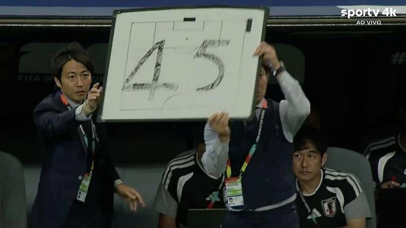 Treinador do Japão com placa durante jogo contra a Holanda