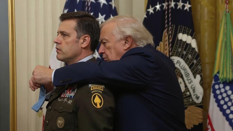 Imagem colorida mostra Trump tentando colocar medalha em militar - Metrópoles