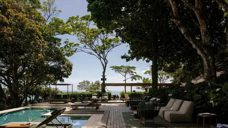 Imersa na natureza, a piscina da Vila Figo equilibra privacidade e vista para o mar de Trancoso, BA. Móveis de área externa da Tidelli